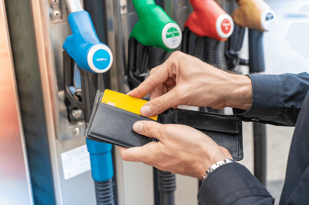 Truckstop.com user holding a wallet in front of a fuel pump.