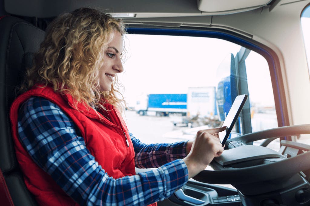 parked truck driver looking at tablet