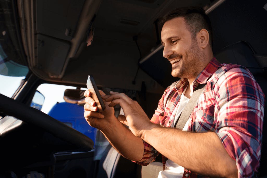 parked truck driver looking at mobile phone