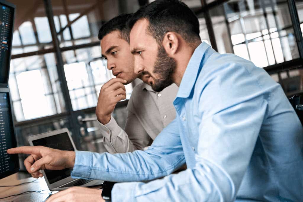 Two brokers looking at a computer screen