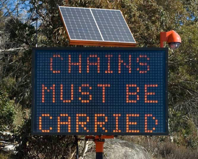 Digital sign that says chains must be carried