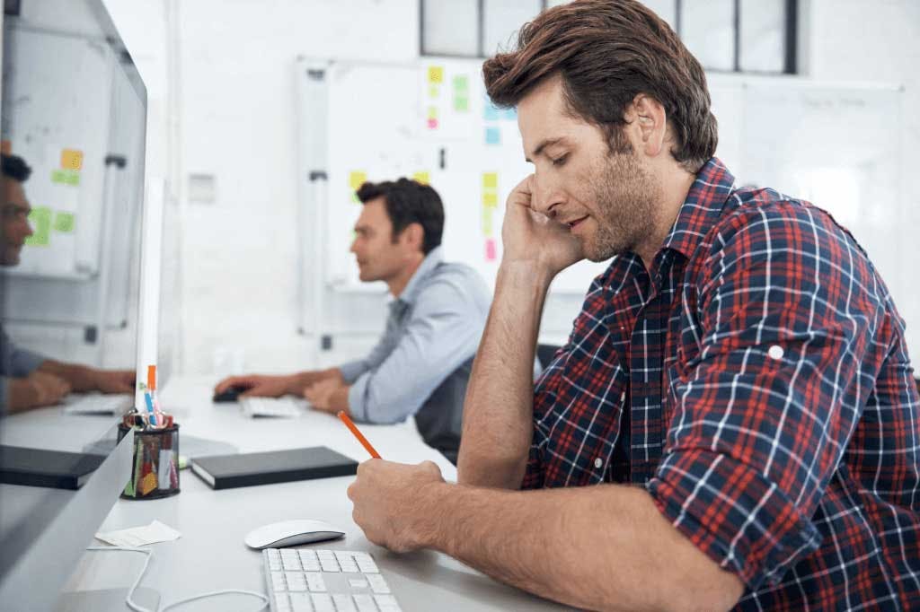 person sitting at a computer on the phone