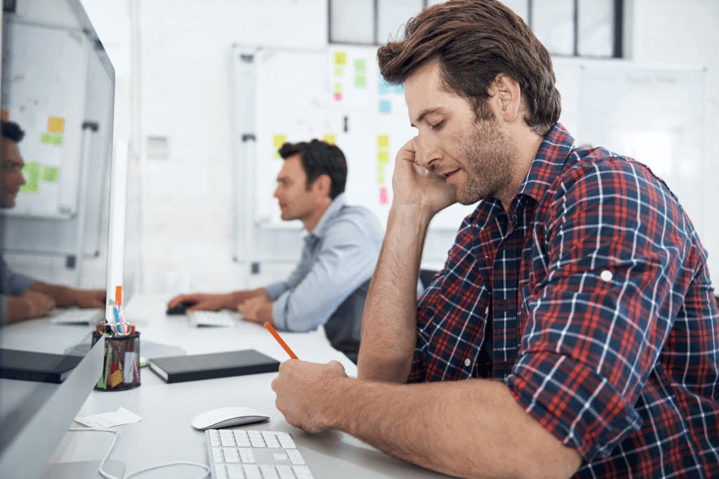 person sitting at a computer on the phone