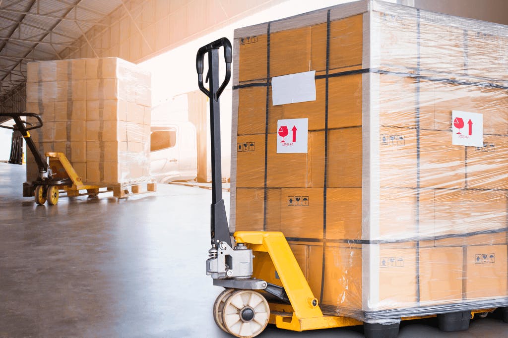 two pallet jacks with loaded skids