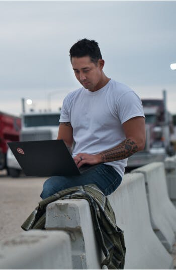Truckstop customer using his laptop to access less than truckload loads.