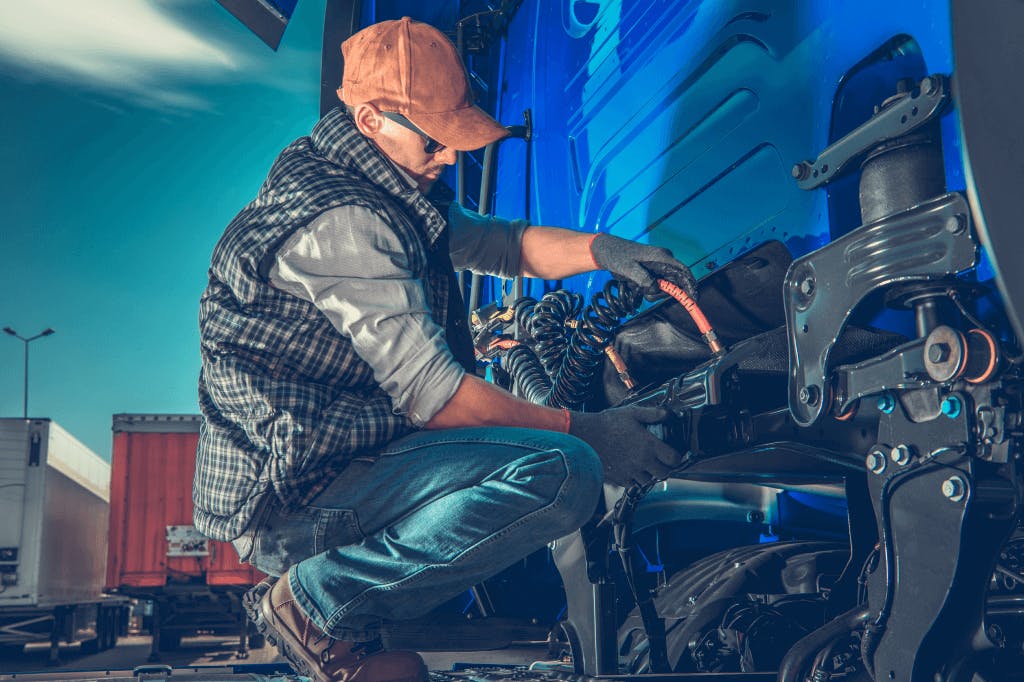 Truck mechanic performing maintenance on long-haul truck