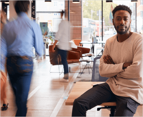 Man Sitting in Coffee Shop Looking into Camera