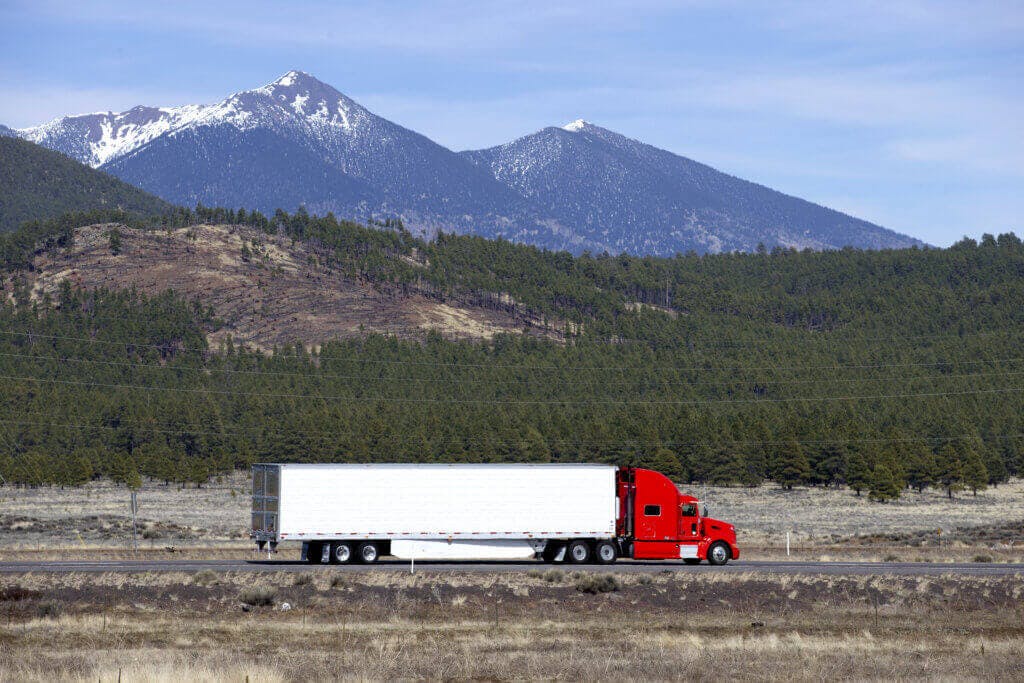 semi truck driving on a highway with a scenic mountain view