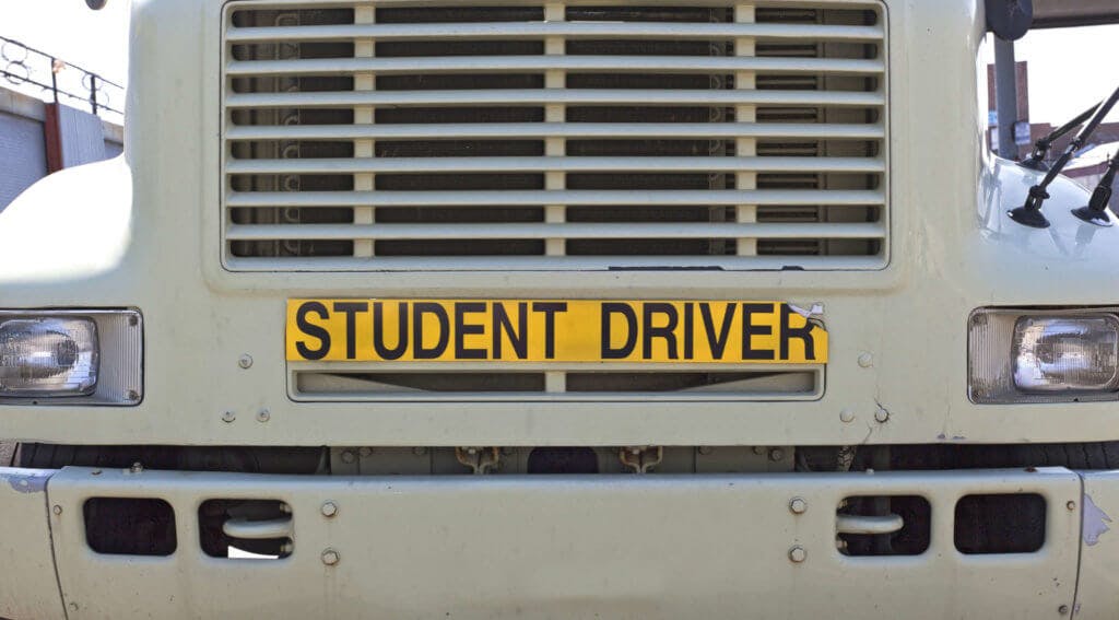 Student driver sign across the grill of a truck.