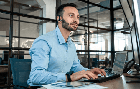 Broker at a desk wearing a headset.