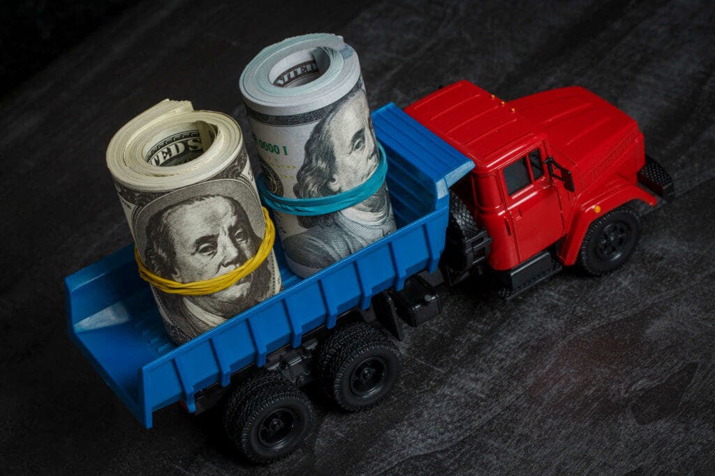 Toy truck with rolls on money in the bed.